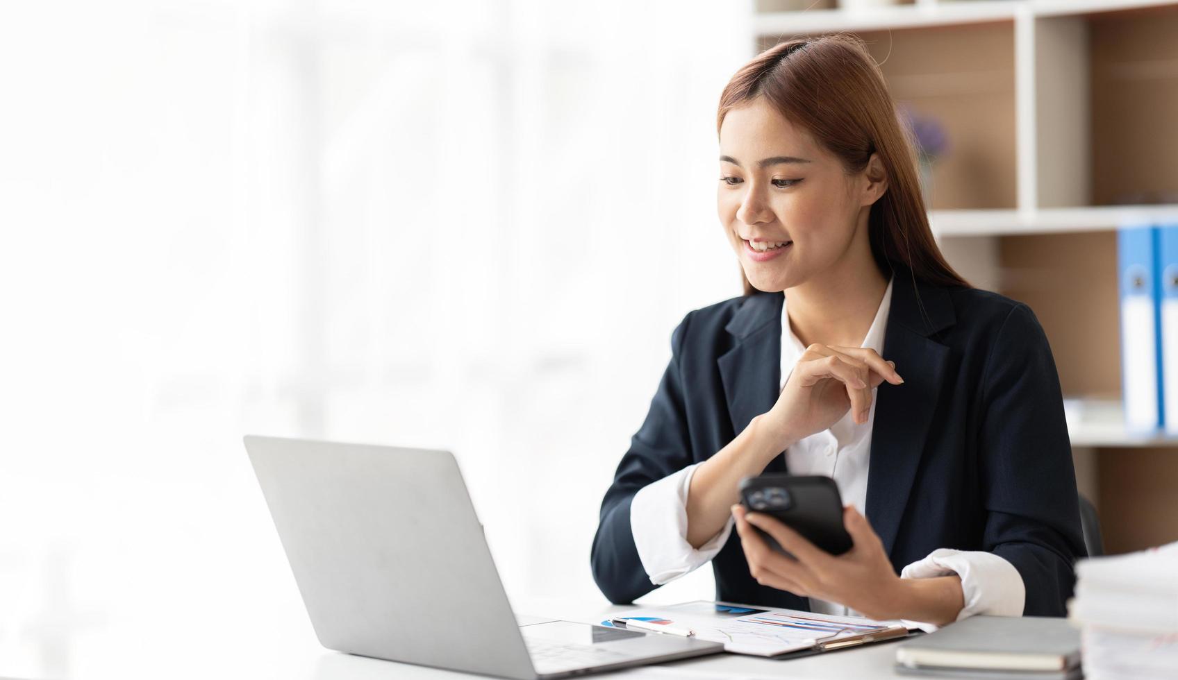 Portrait of confident businesswoman at workplace, smiling woman employee sitting behind laptop. photo