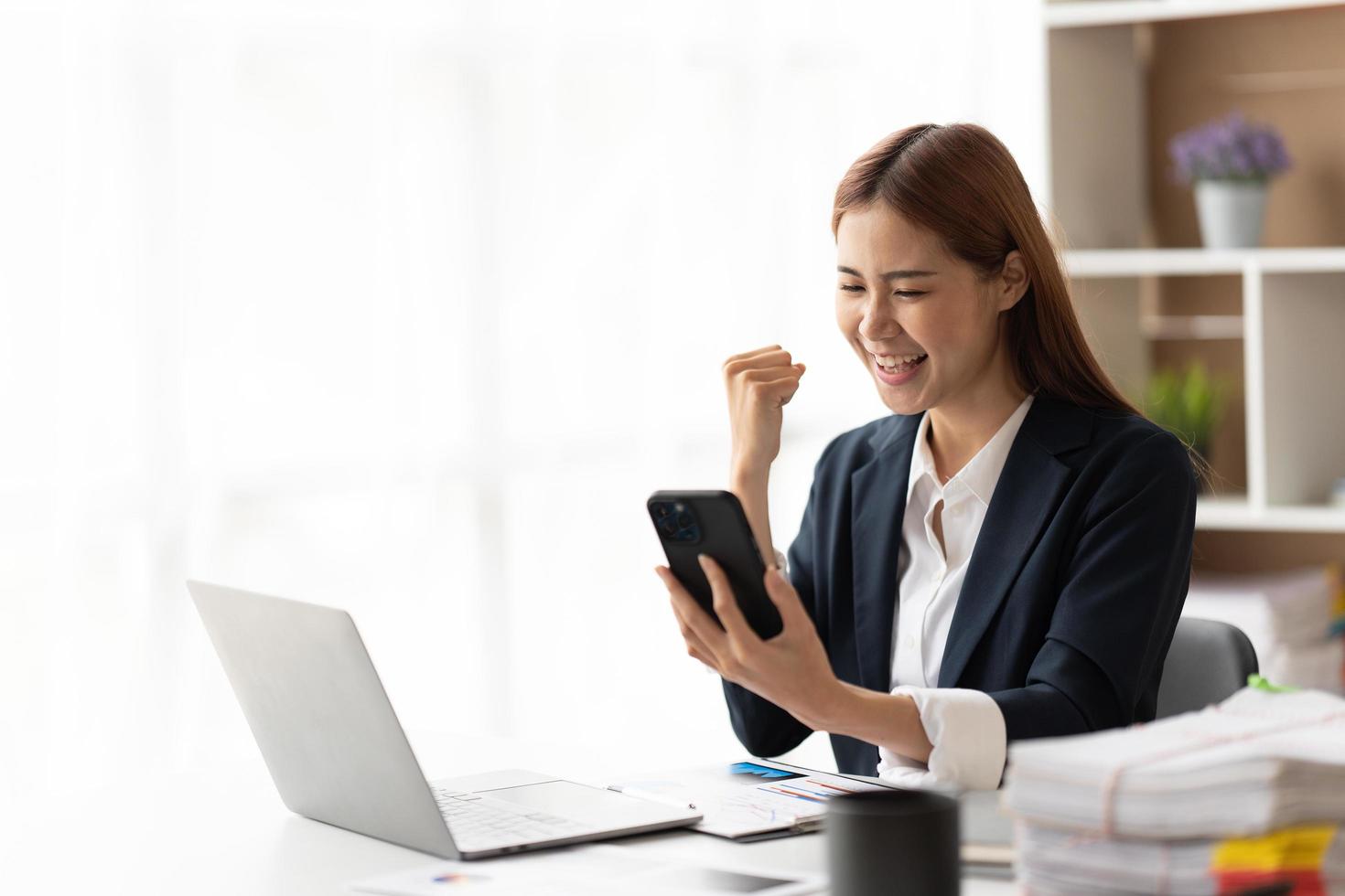 Online shopping and beauty concept. Excited asian woman winning in internet, holding smartphone and rejoicing, smiling happy and celebrating. photo