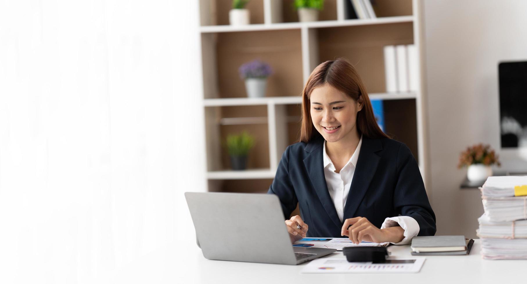 Portrait of confident businesswoman at workplace, smiling woman employee sitting behind laptop. photo