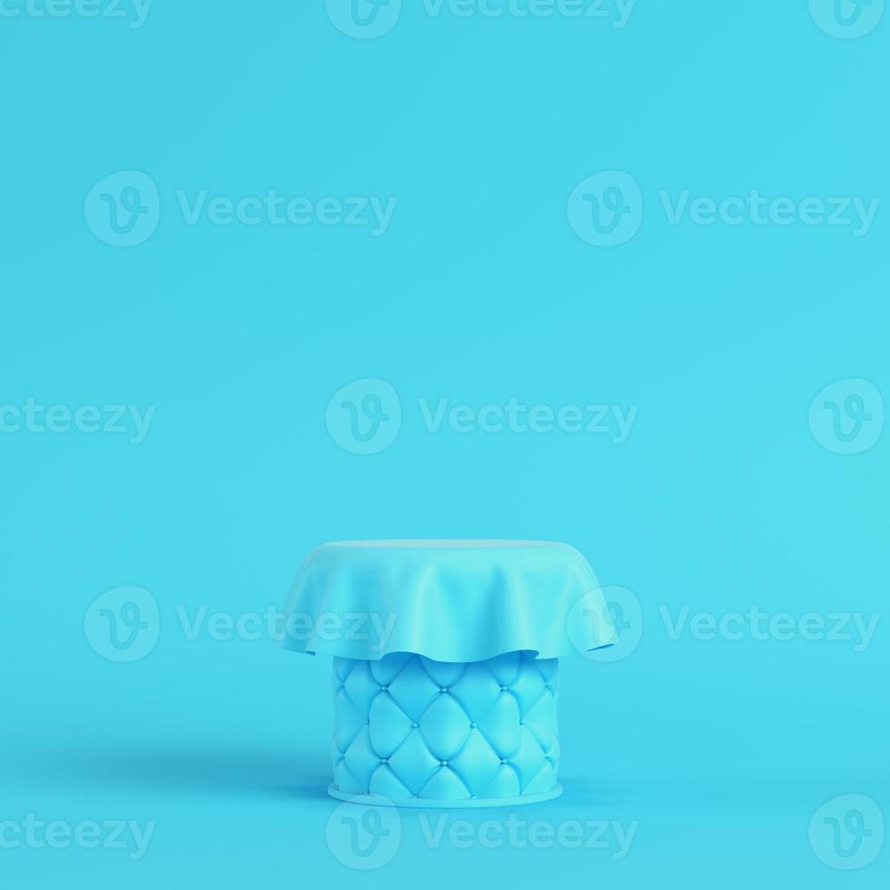 Stitched pedestal covered by fabric on bright blue background in pastel colors photo