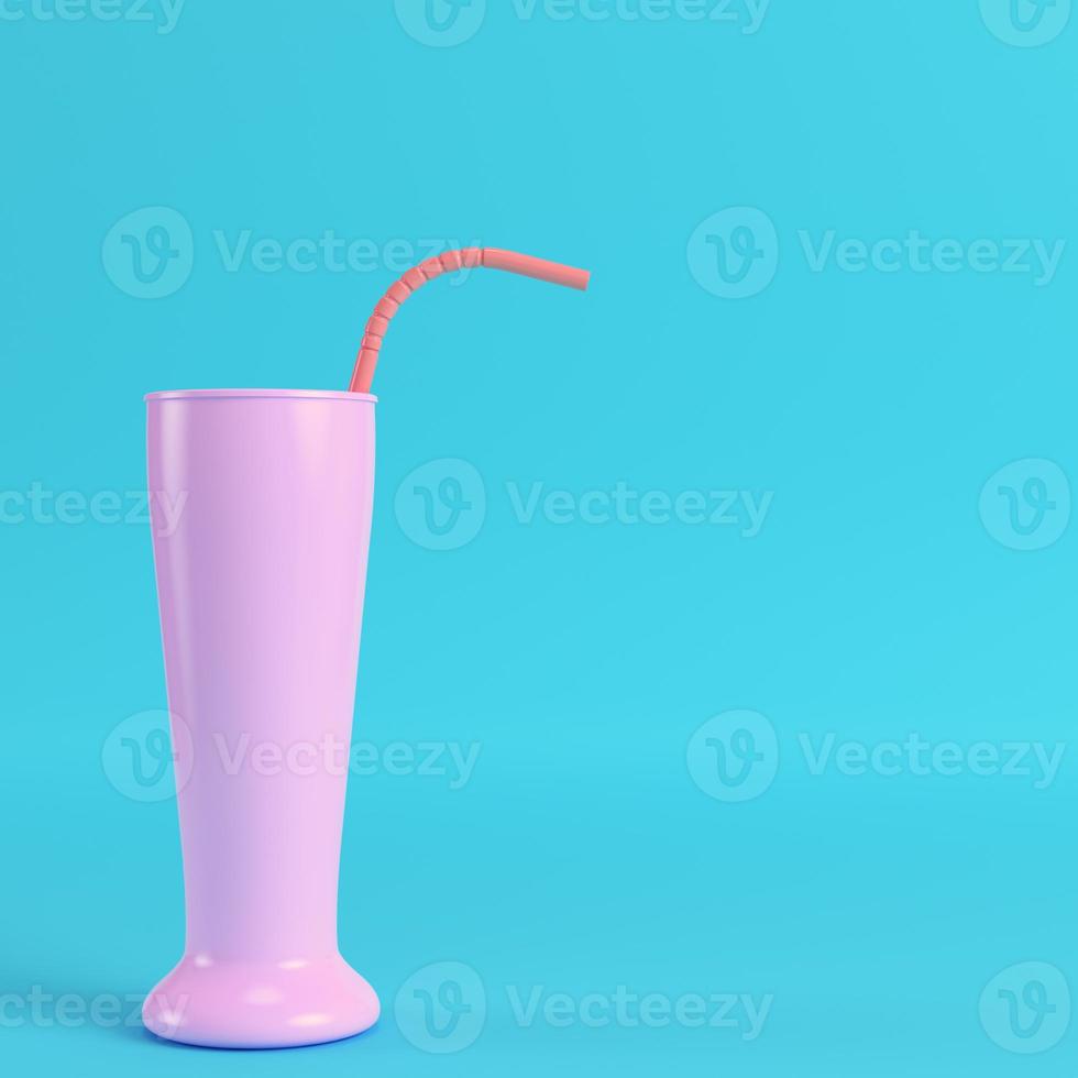 Cocktail glass with straw on bright blue background photo