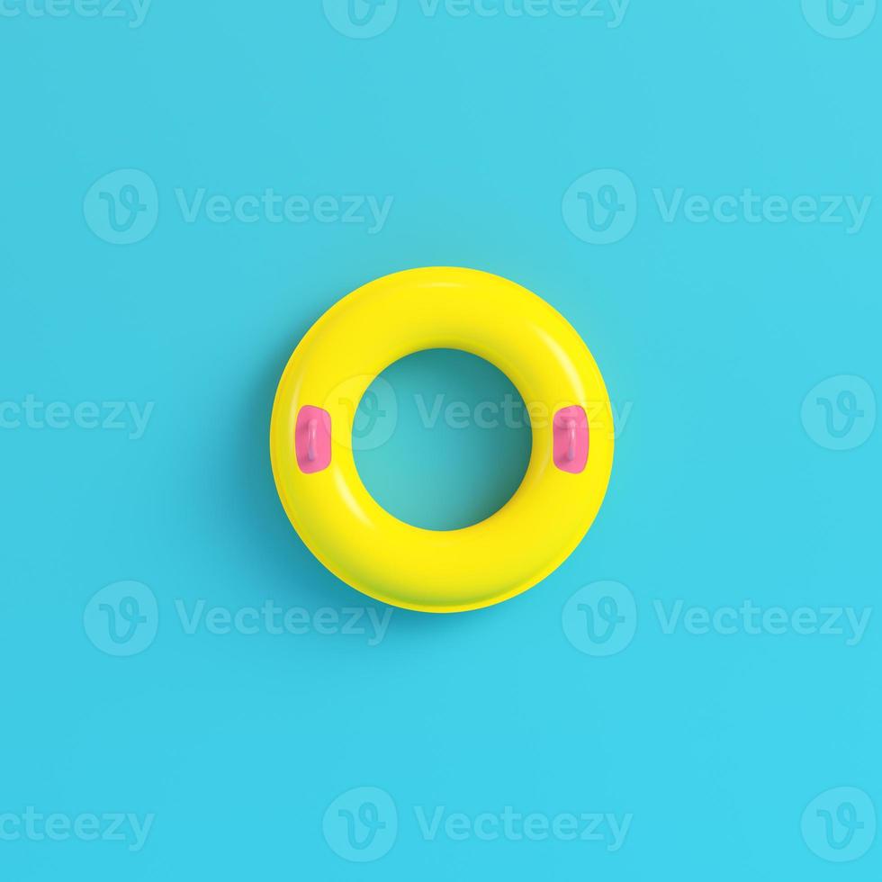Yellow inflatable ring on bright blue background in pastel colors photo