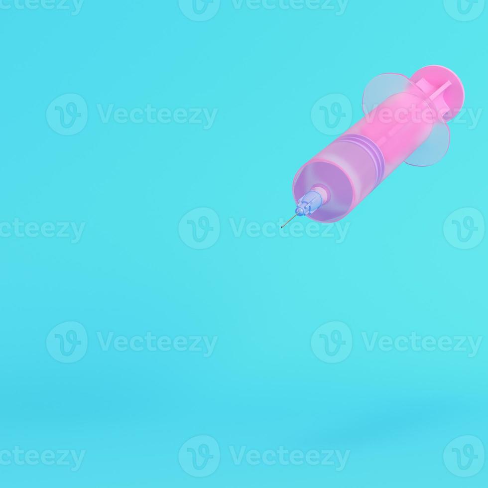 Pink syringe with vaccine on bright blue background in pastel colors photo