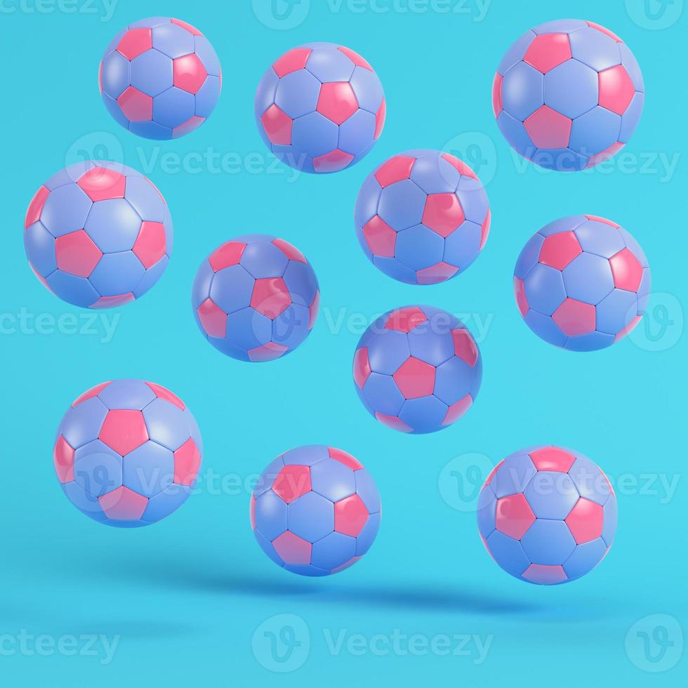 Pink flying soccer balls on bright blue background in pastel colors photo