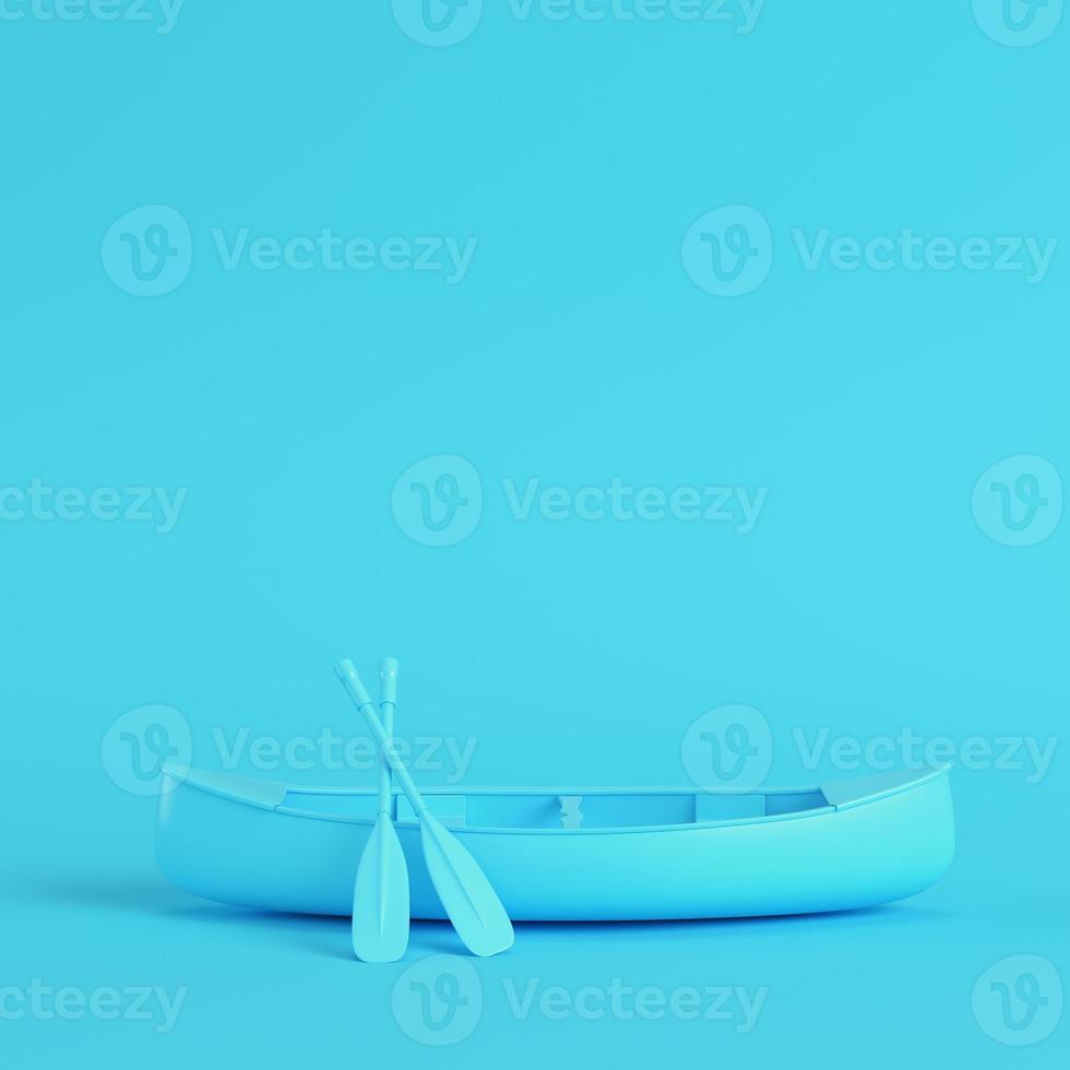 Canoe with paddles on bright blue background in pastel colors photo