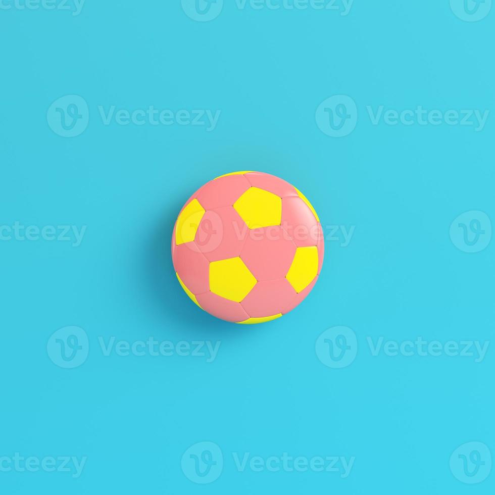 Yellow soccer ball on bright blue background in pastel colors photo