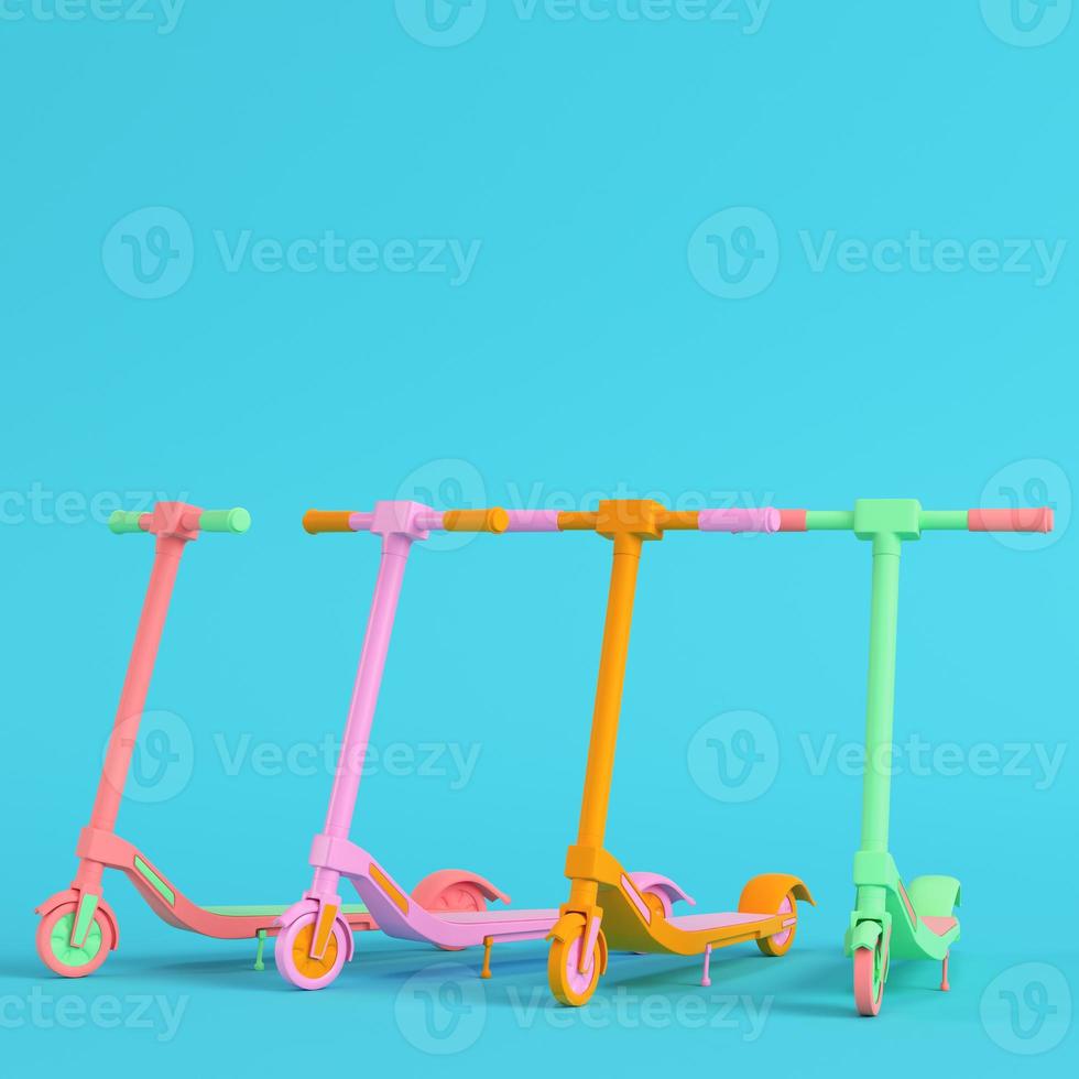 Four colorful kick scooters on bright blue background in pastel colors. Minimalism concept photo