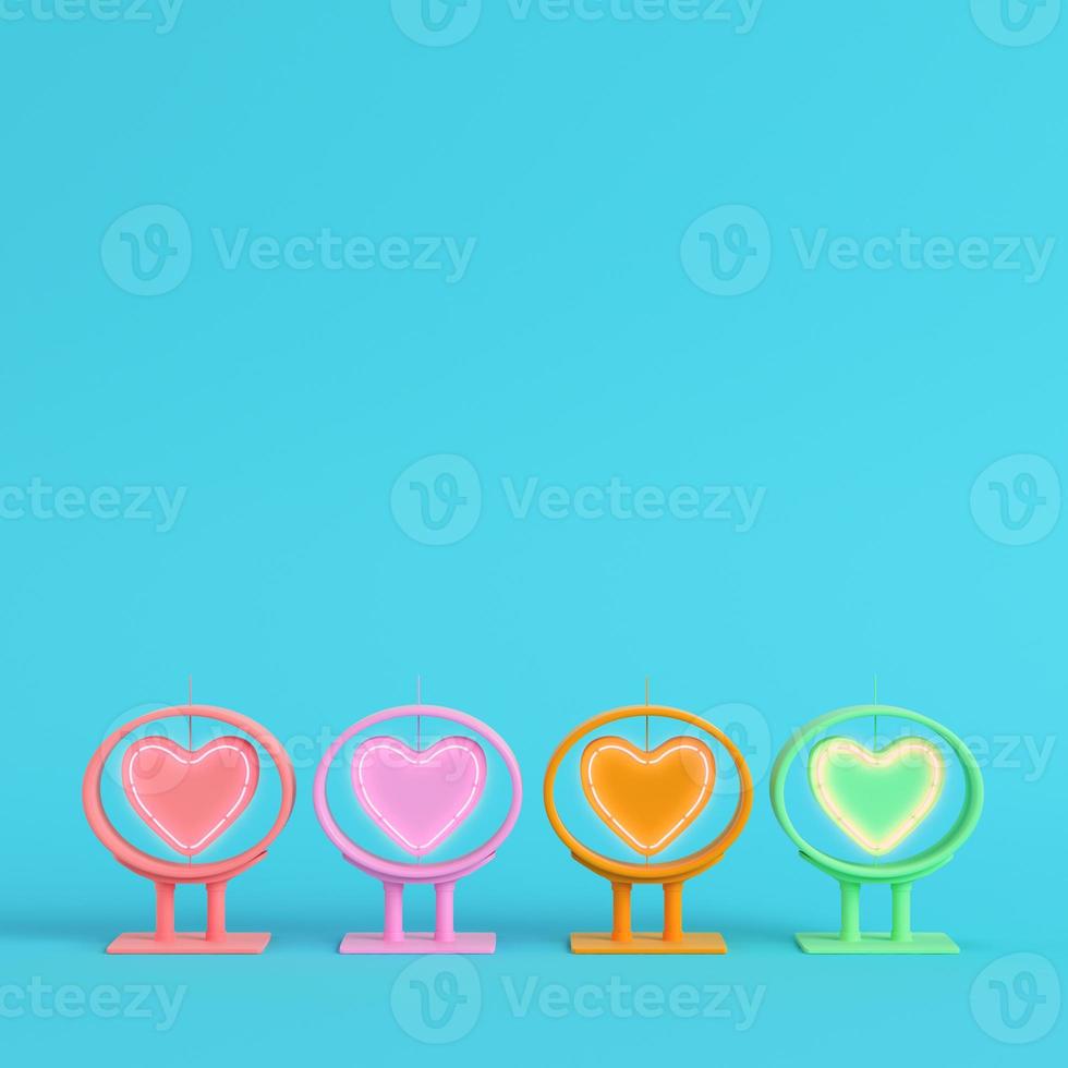 Four colorful neon heart shape in frame on bright blue background in pastel colors photo