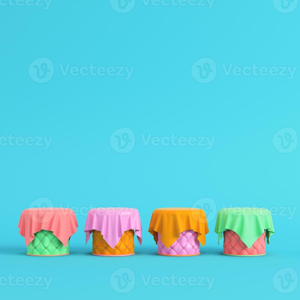 Stitched pedestals covered by fabric with round frame on bright blue background in pastel colors photo