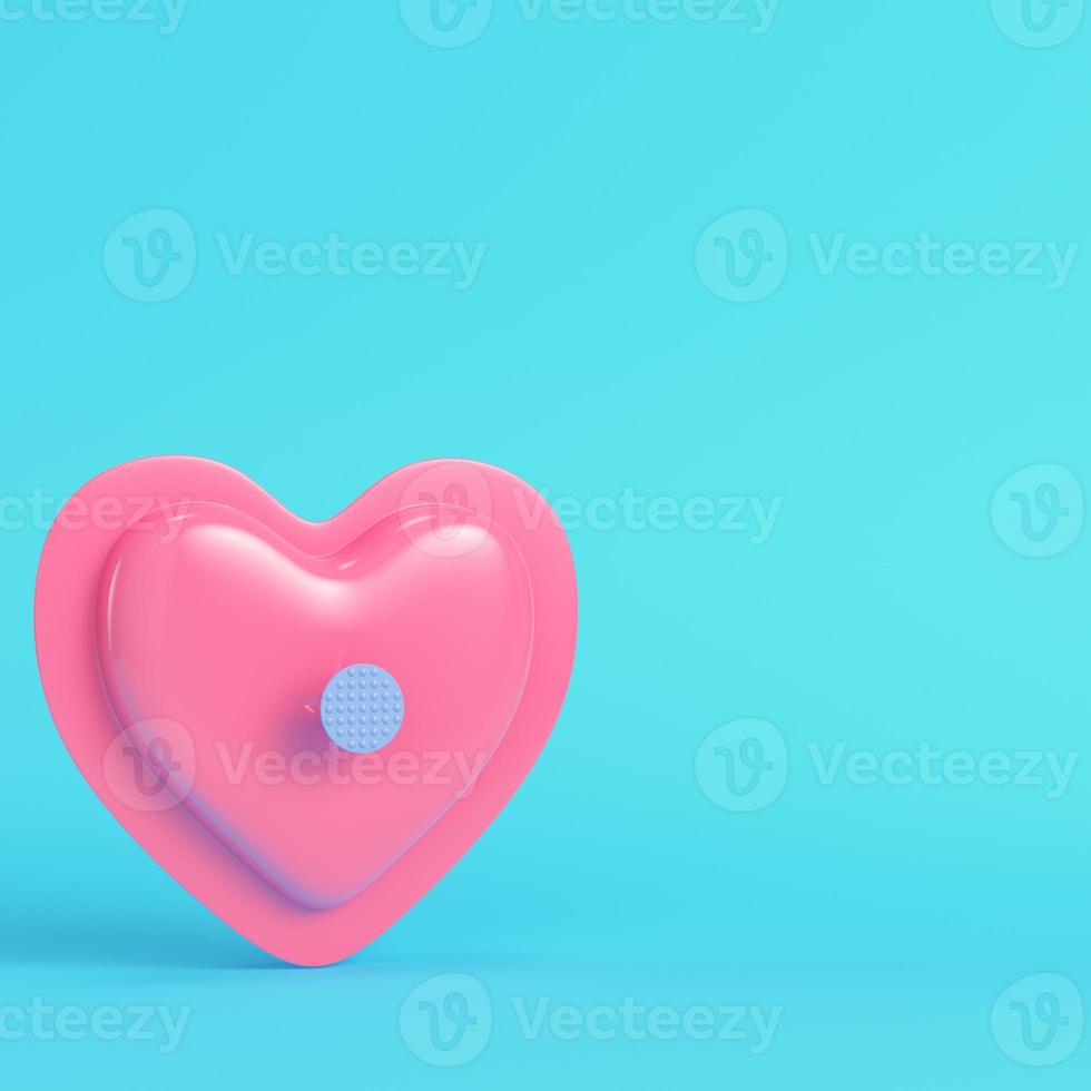 Pink abstract heart shape pinned by nail on bright blue background in pastel colors photo