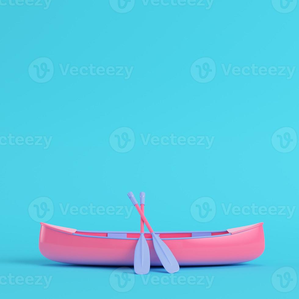 Pink canoe with paddles on bright blue background in pastel colors photo