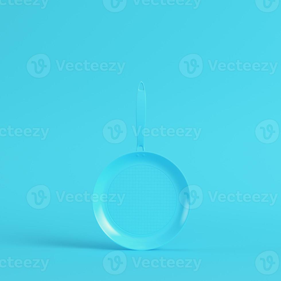 Frying pan on bright blue background in pastel colors photo