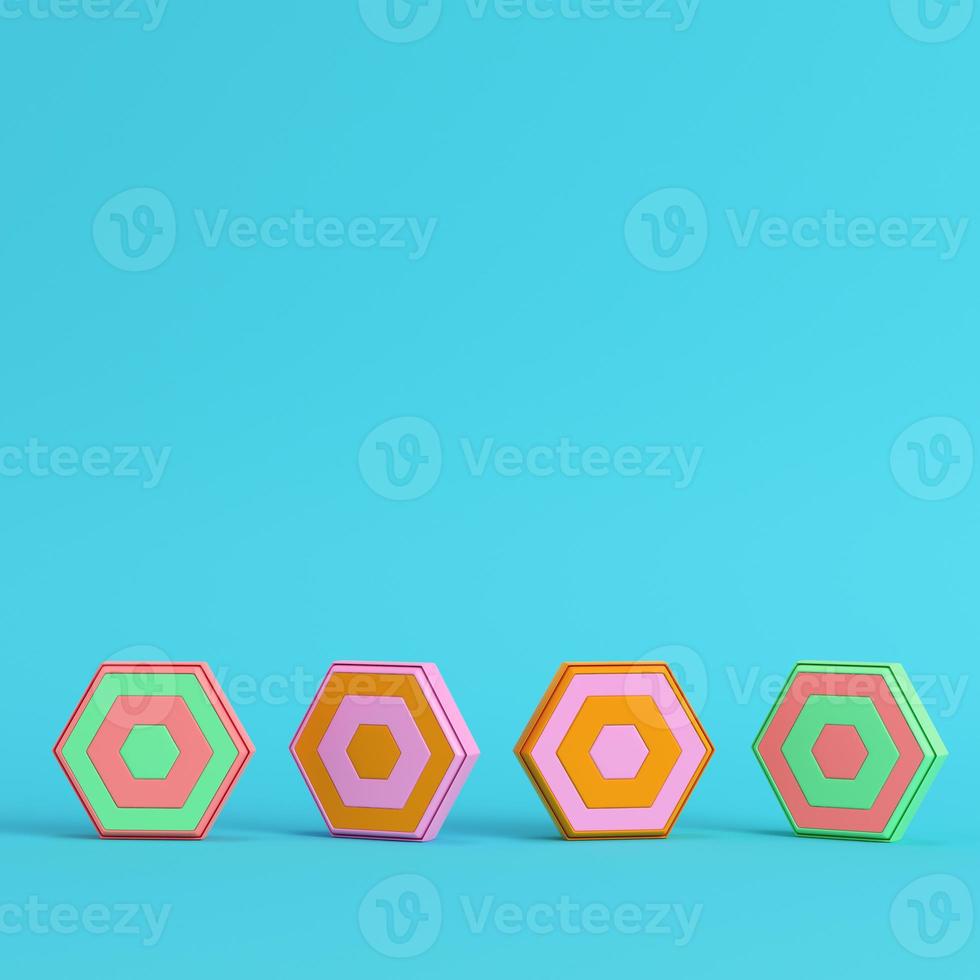 Four colorful abstract hexagons on bright blue background in pastel colors. photo