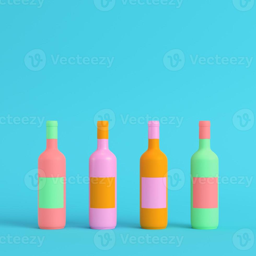 Four colorful wine bottles on bright blue background in pastel colors. Minimalism concept photo