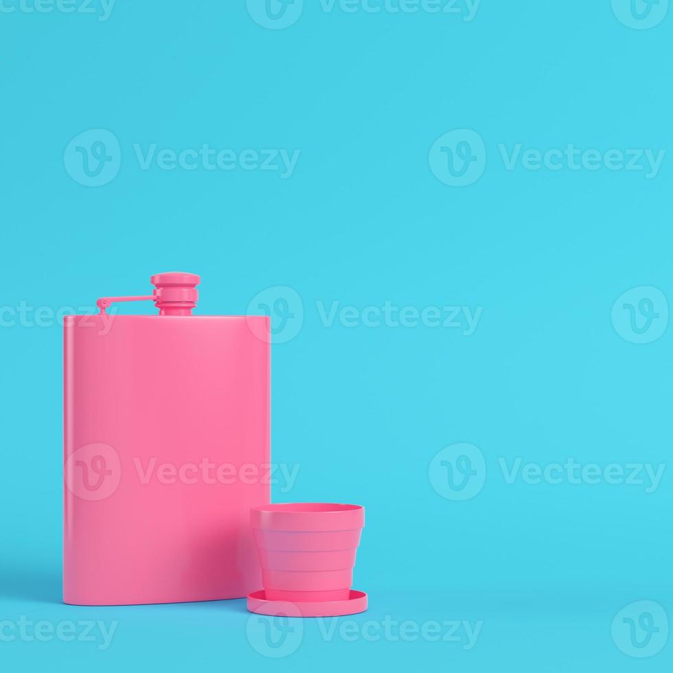 Pink hip flask with cup on bright blue background in pastel colors photo