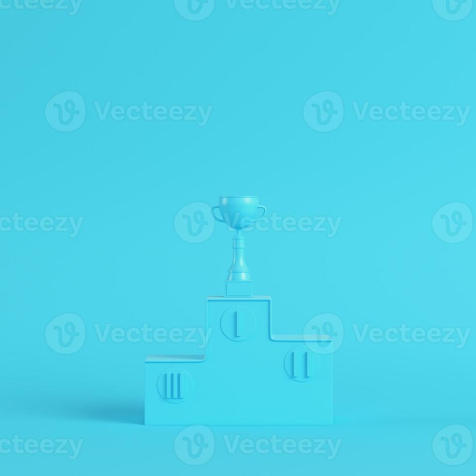 Pedestal with trophy cup on bright blue background in pastel colors. Minimalism concept photo