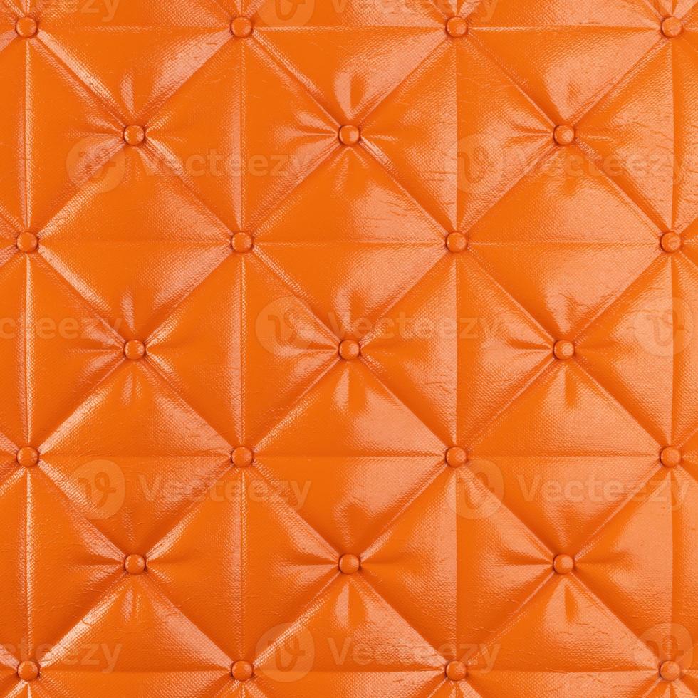 Stitched upholstery leather orange background with buttons photo