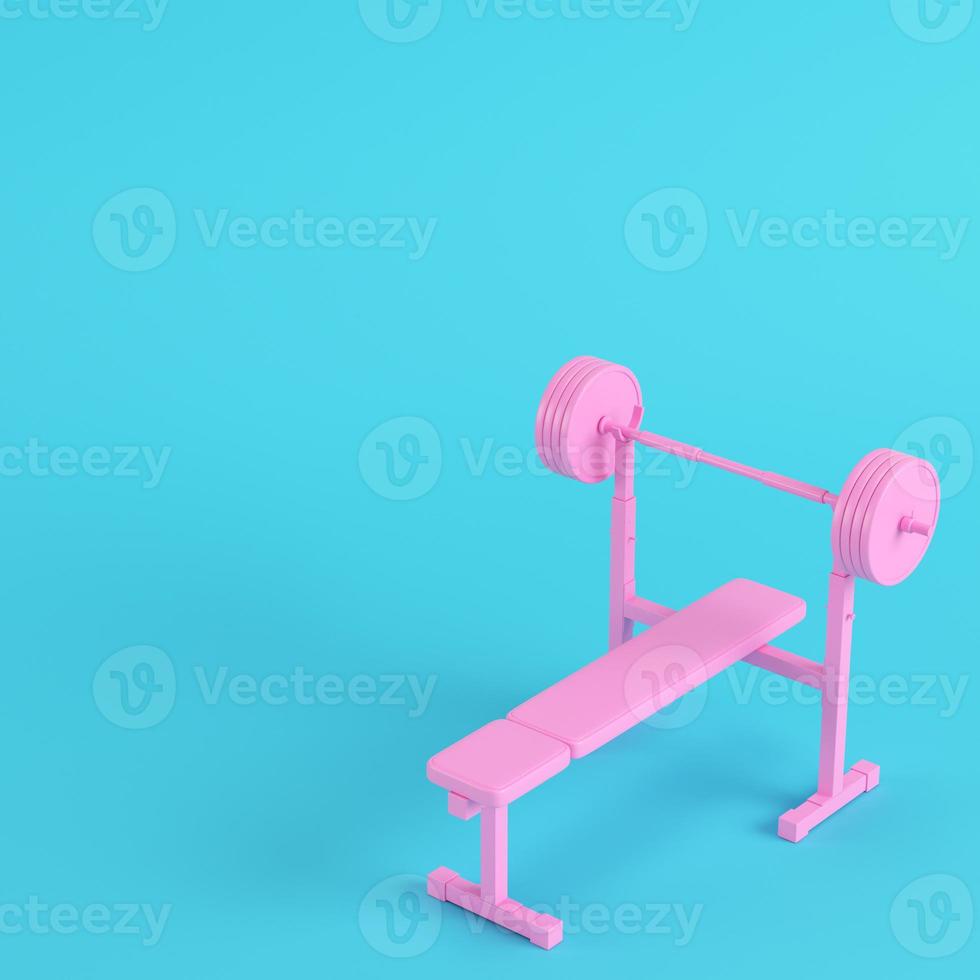 Pink barbell with bench with ball on bright blue background in pastel colors. Minimalism concept photo