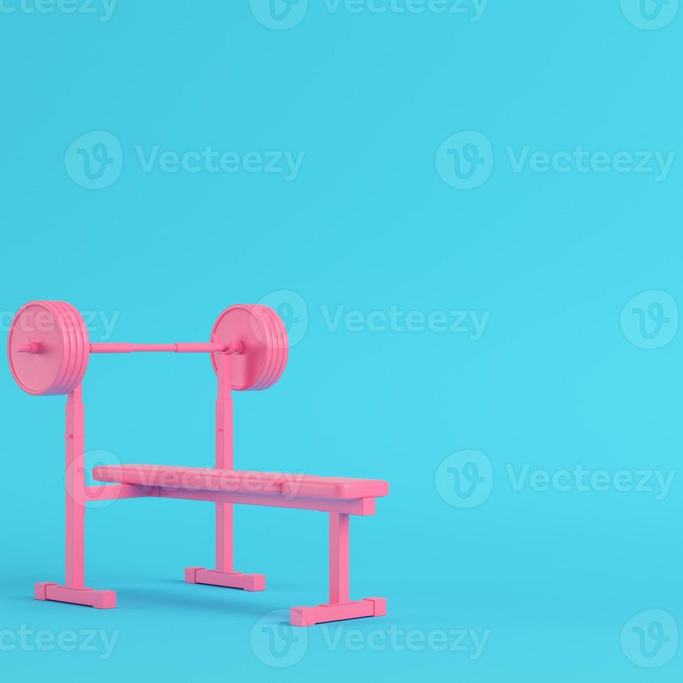 Pink barbell with bench with ball on bright blue background in pastel colors. Minimalism concept photo
