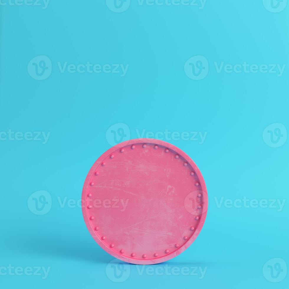 Pink blank scratched coin on bright blue background in pastel colors photo