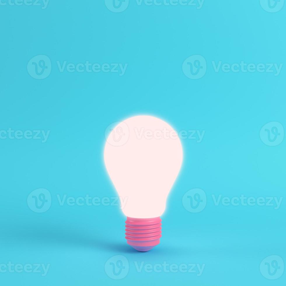 Pink glowing light bulb on bright blue background in pastel colors photo