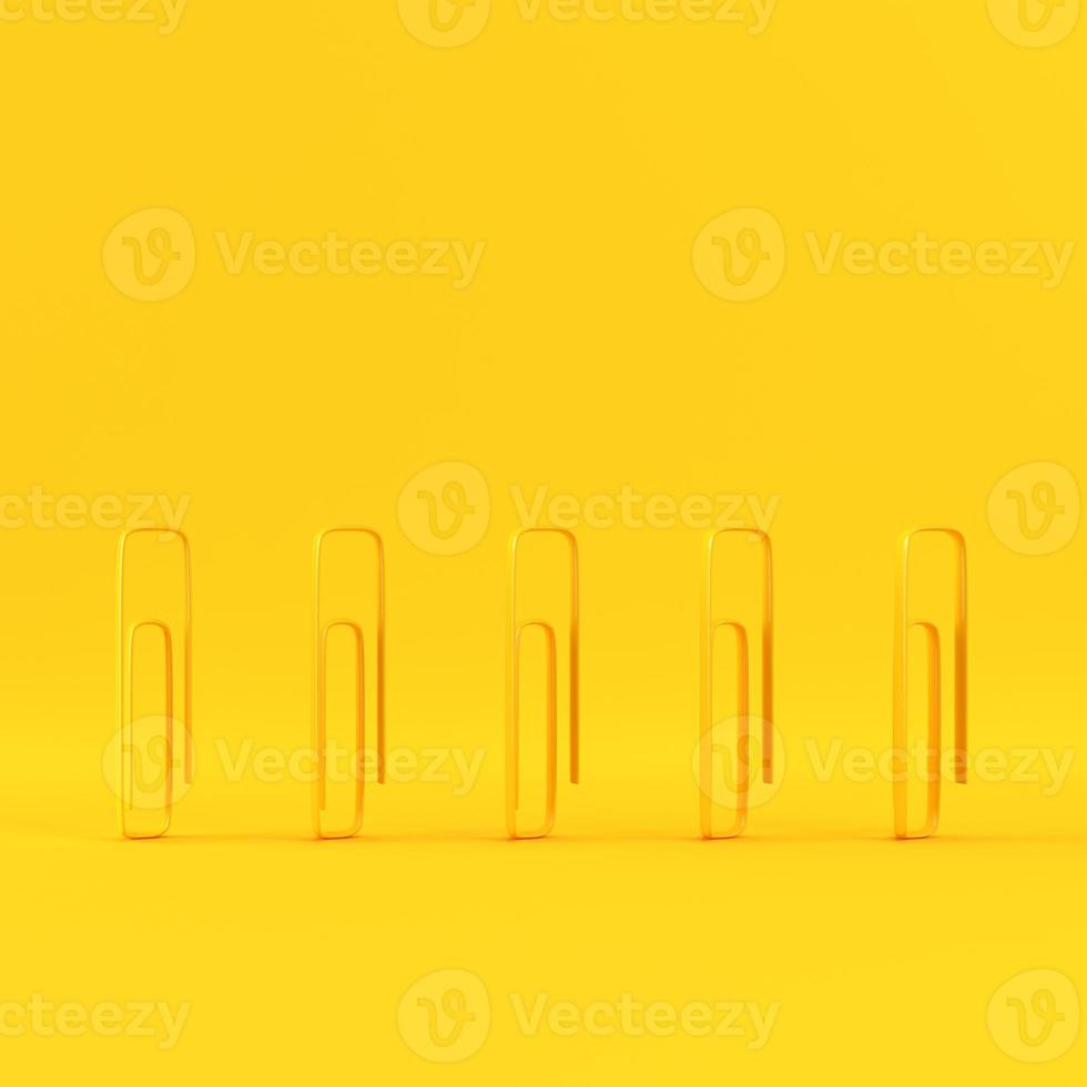 Paper clips on yellow background with copy space photo