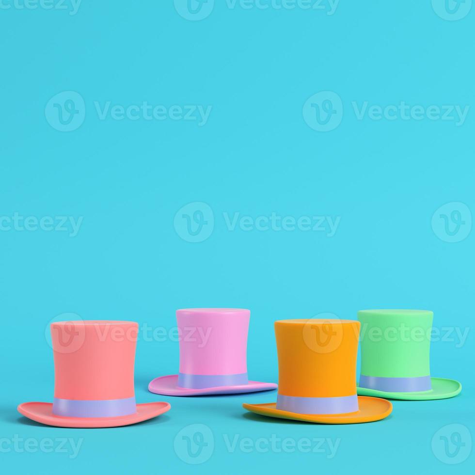 Four colorful top hats on bright blue background in pastel colors. Minimalism concept photo