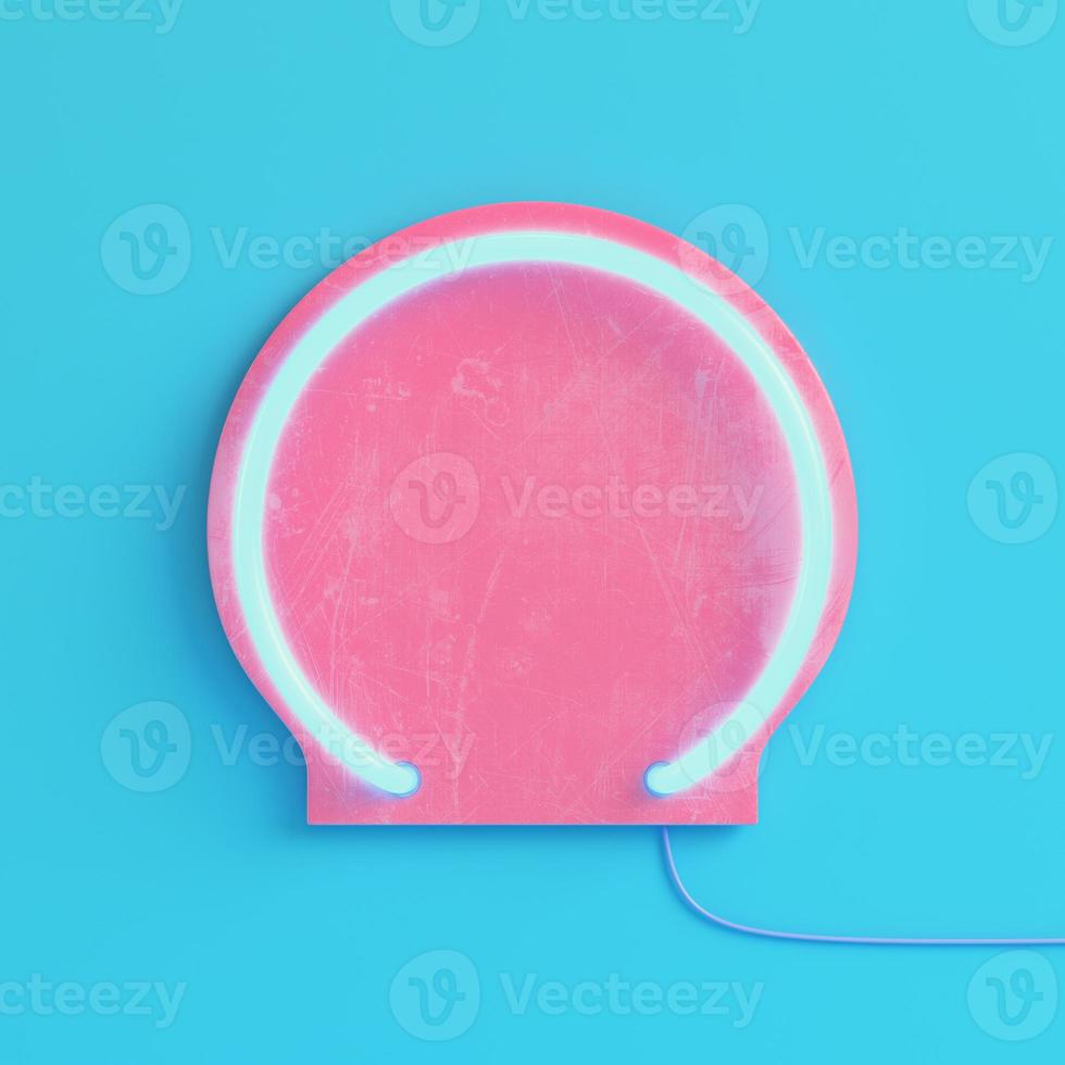 Pink plate with neon light on bright blue background in pastel colors photo
