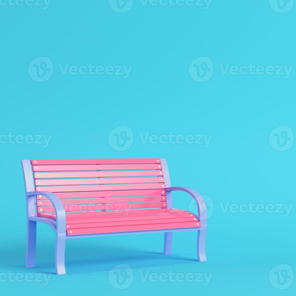 Pink street bench on bright blue background in pastel colors photo
