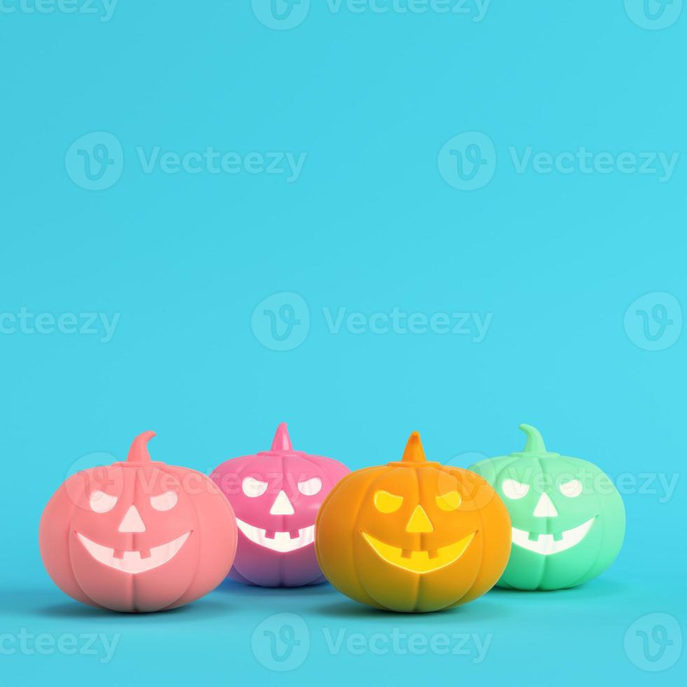 cuatro coloridas calabazas de halloween, jack o linterna sobre fondo azul brillante en colores pastel foto