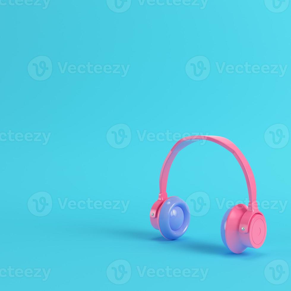 Pink headphones on bright blue background in pastel colors photo