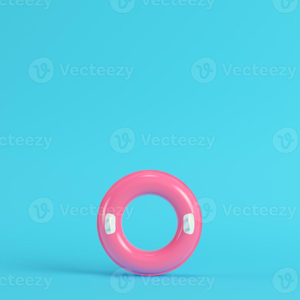 Pink inflatable ring on bright blue background in pastel colors photo