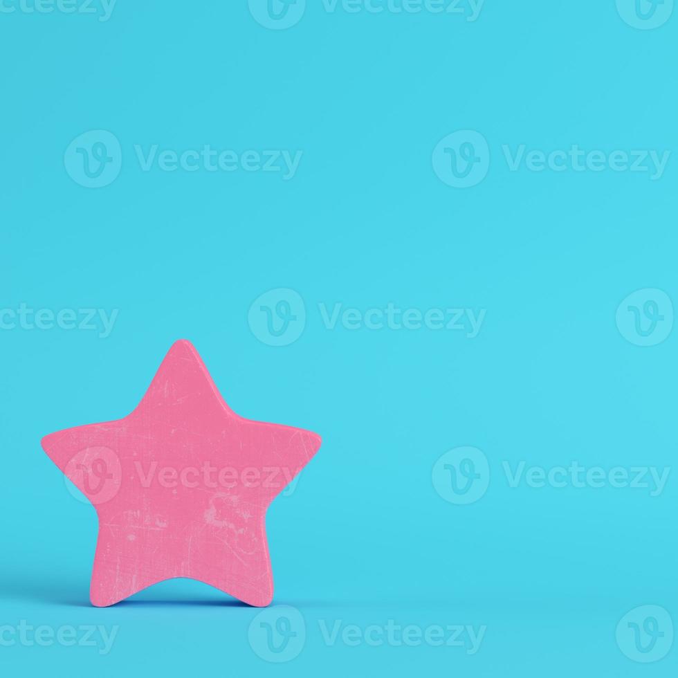 Pink abstract star on bright blue background in pastel colors photo