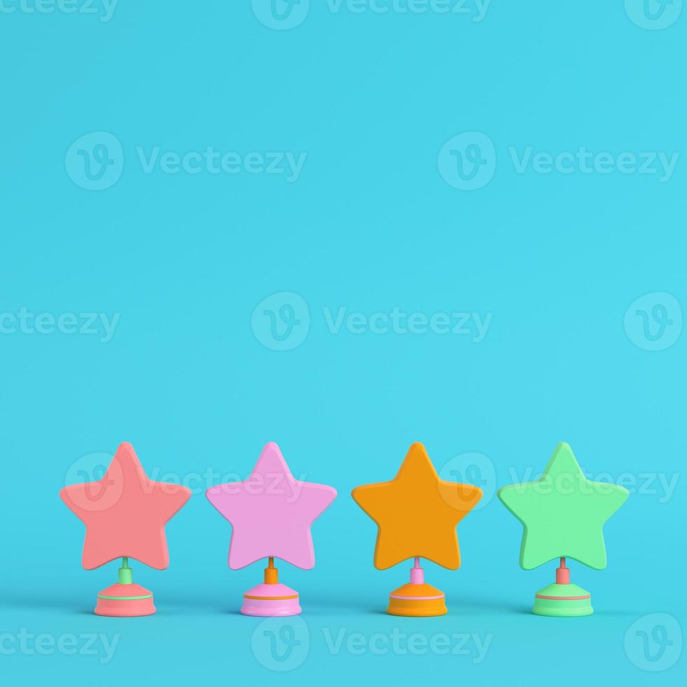 Four colorful stars with stands on bright blue background in pastel colors. Minimalism concept photo