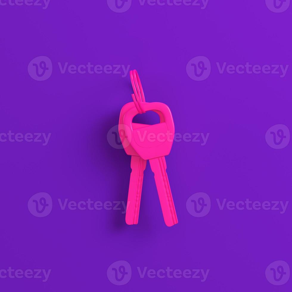 Pink home or car keys on purple background. Minimalism concept photo