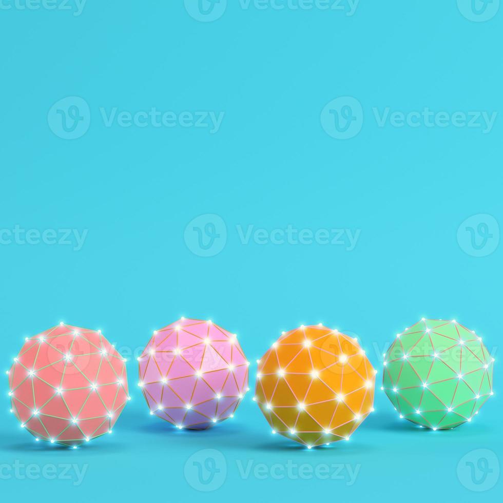 Four colorful low poly abstract glowing spheres on bright blue background in pastel colors photo