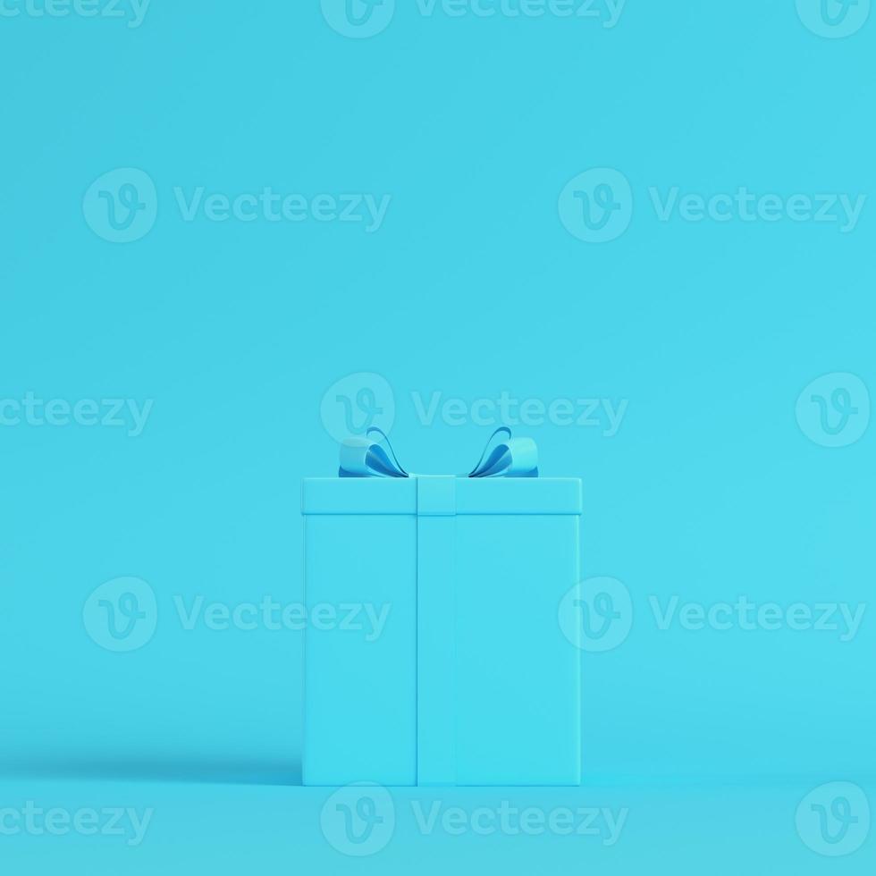 gift box with ribbon bow on bright blue background in pastel colors photo