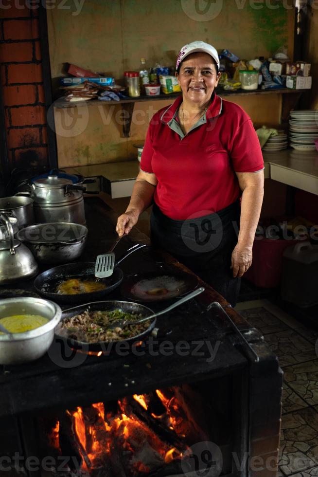 Woman cooking on a wood stove. photo