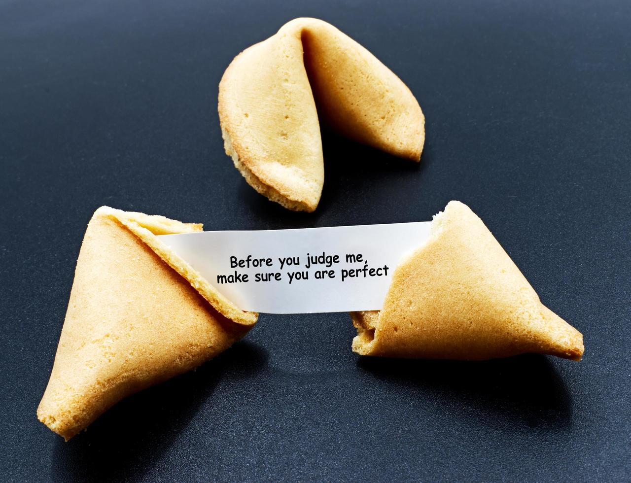 Antes de juzgarme, asegúrate de que eres perfecto. galleta de la fortuna china agrietada con mensaje motivacional. foto