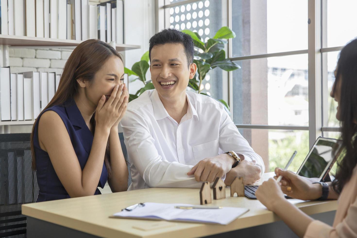 Happy young loving couple talking to their real estate agent with smile looking at house , Planning for the future of the family concept photo