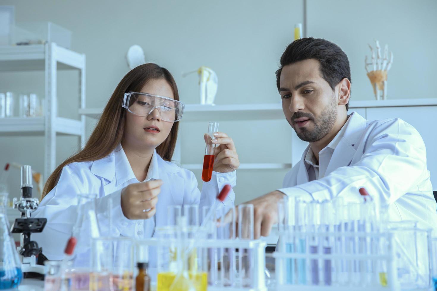 Attractive scientist medical worker with sample test tube at laboratory , doing a analysis in a laboratory doing research to create a vaccine and development photo