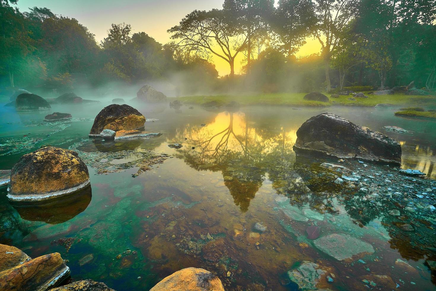 baño natural de aguas termales onsen en el parque nacional chae son, lampang tailandia. en el amanecer de la mañana. baño de aguas termales natural rodeado de montañas en el norte de tailandia. enfoque suave. foto