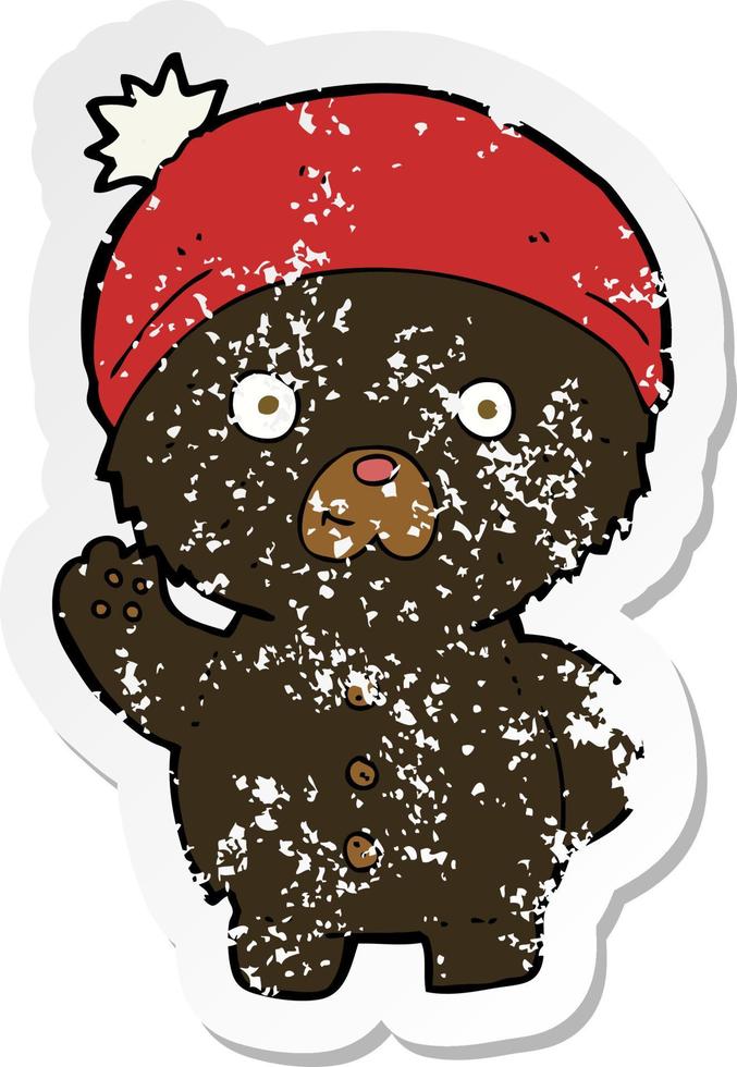 retro distressed sticker of a cartoon waving black teddy bear in winter hat vector