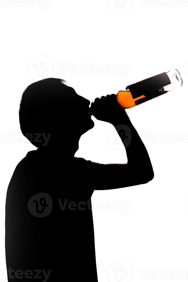 young man drinking alcohol from bottle. young drunkard holding bottle and standing photo