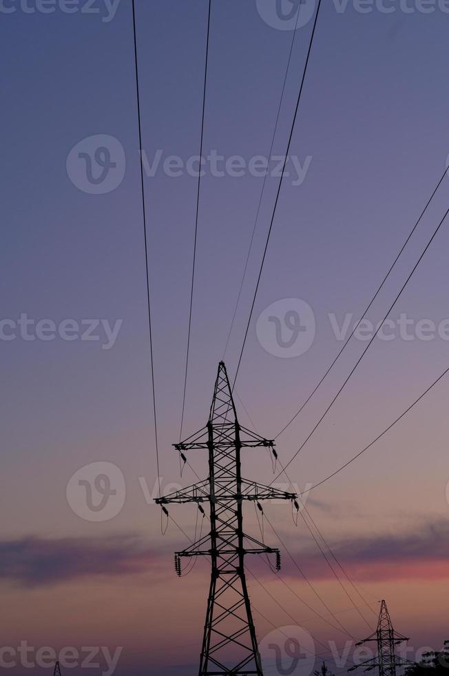 cerrar la estación de líneas eléctricas de alta tensión. torre de silueta de pilón de transmisión eléctrica de alto voltaje. foto