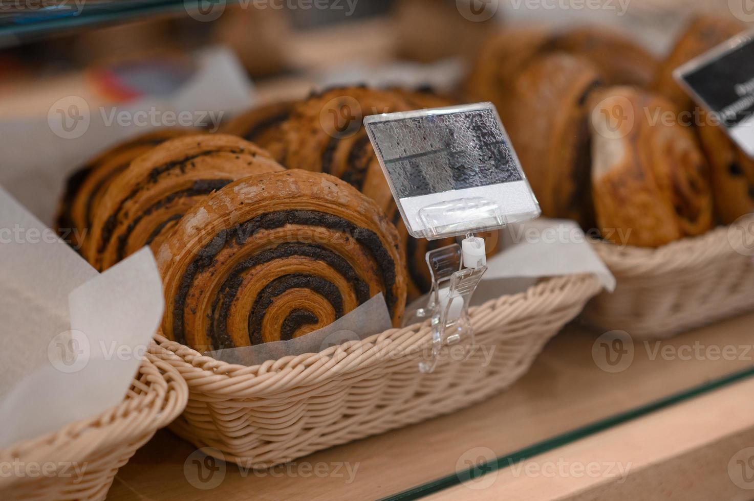 una variedad de productos horneados están en exhibición. escaparate en la panadería. varios bollos y pasteles foto