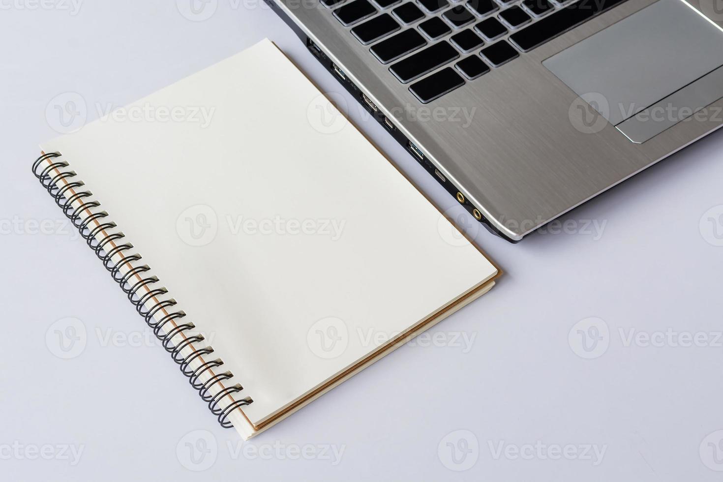 Notebook with computer on white table photo