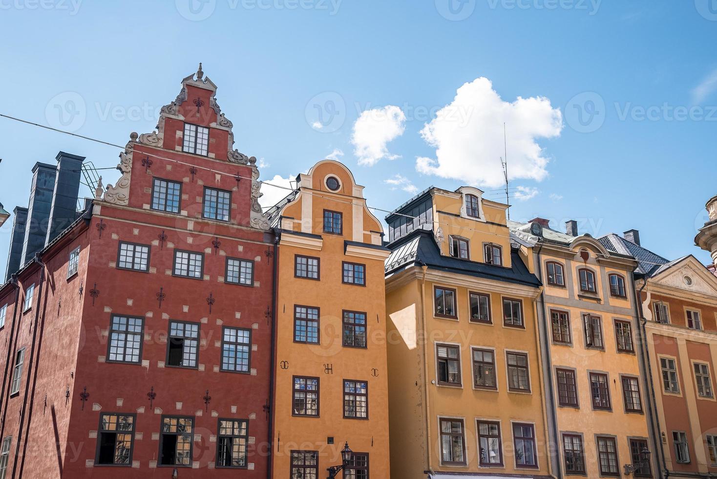 Beautiful facade of colorful buildings in old town square against blue sky photo