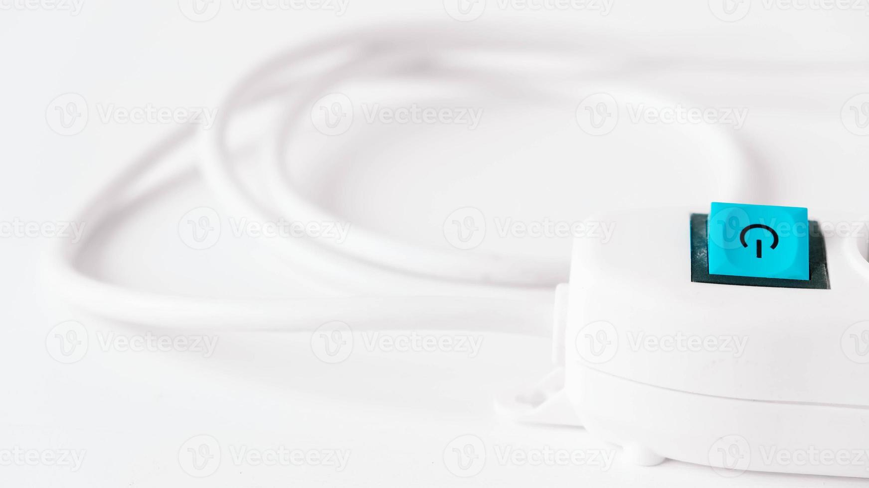 Modern white electric extension cord with a button on a white background photo