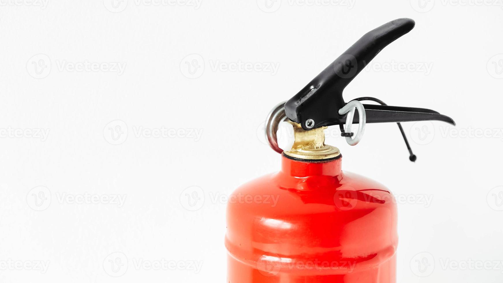 Red fire extinguisher on a white wall background photo